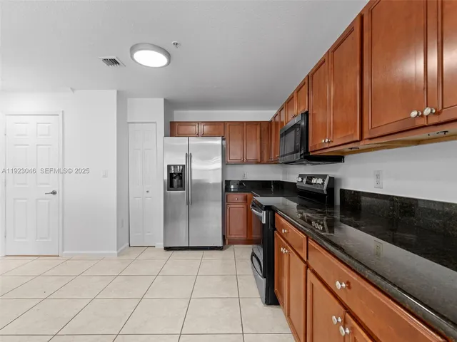 a kitchen with stainless steel appliances granite countertop a refrigerator a sink and dishwasher