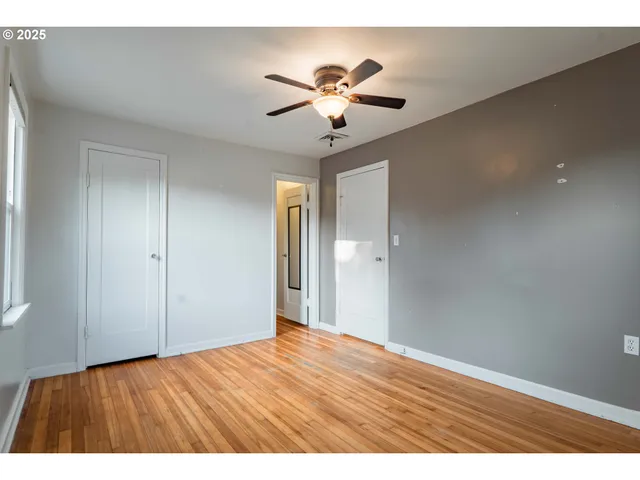 a view of an empty room with a chandelier fan