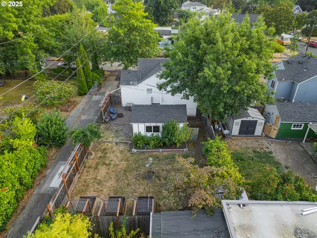 an aerial view of a house with a yard potted plants and large tree