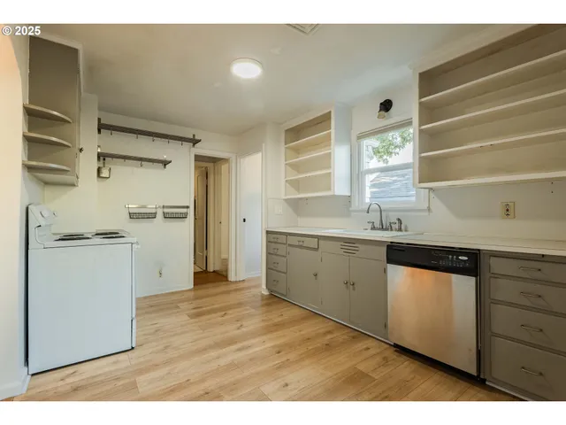 a kitchen with a sink cabinets stainless steel appliances and a window