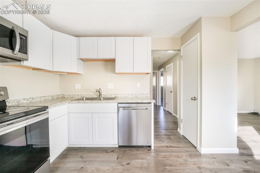 6610 Dublin Loop West, Unit 2 Colorado Springs, CO 80918 - Photo 11 of 50 a kitchen with stainless steel appliances granite countertop a stove a sink and a refrigerator