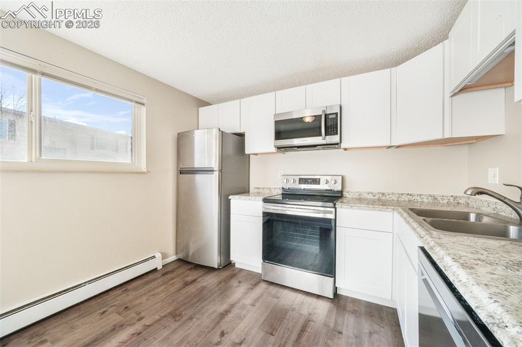 6610 Dublin Loop West, Unit 2 Colorado Springs, CO 80918 - Photo 13 of 50 a kitchen with stainless steel appliances granite countertop a refrigerator stove and sink