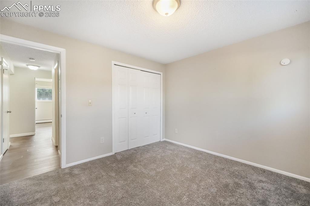 6610 Dublin Loop West, Unit 2 Colorado Springs, CO 80918 - Photo 27 of 50 an empty room with wooden floor and windows