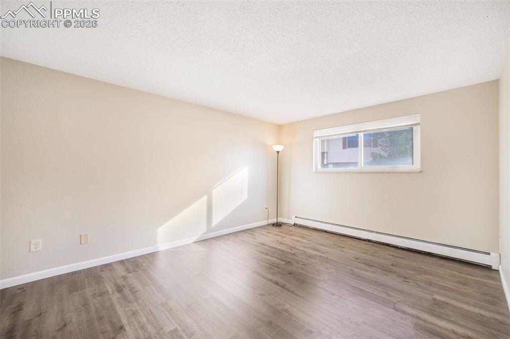 6610 Dublin Loop West, Unit 2 Colorado Springs, CO 80918 - Photo 4 of 50 an empty room with wooden floor and windows