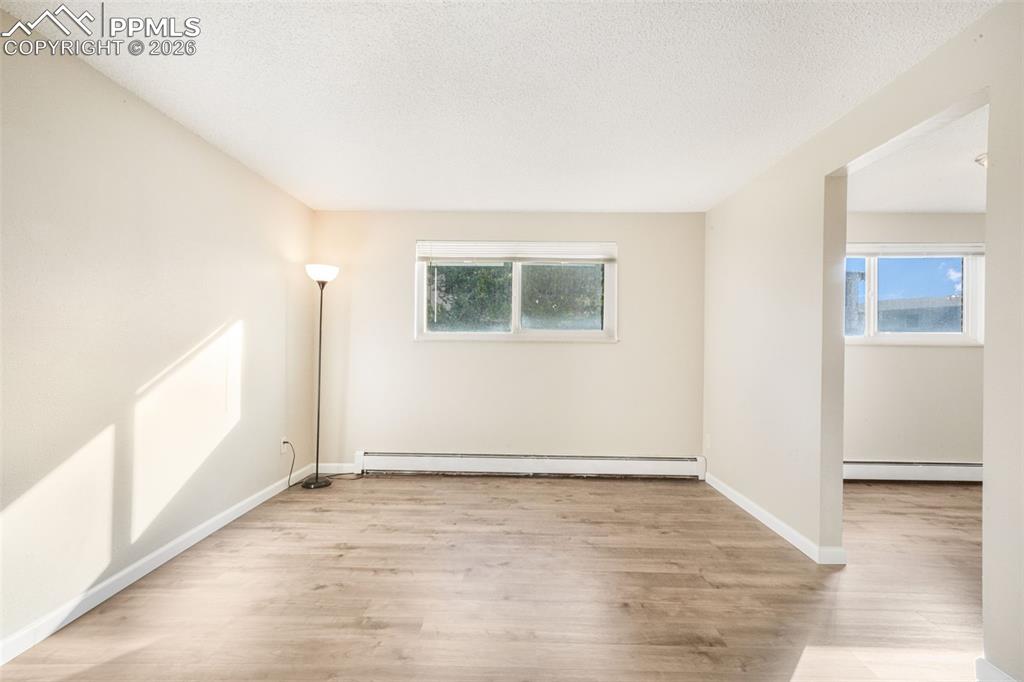 6610 Dublin Loop West, Unit 2 Colorado Springs, CO 80918 - Photo 5 of 50 an empty room with wooden floor and windows