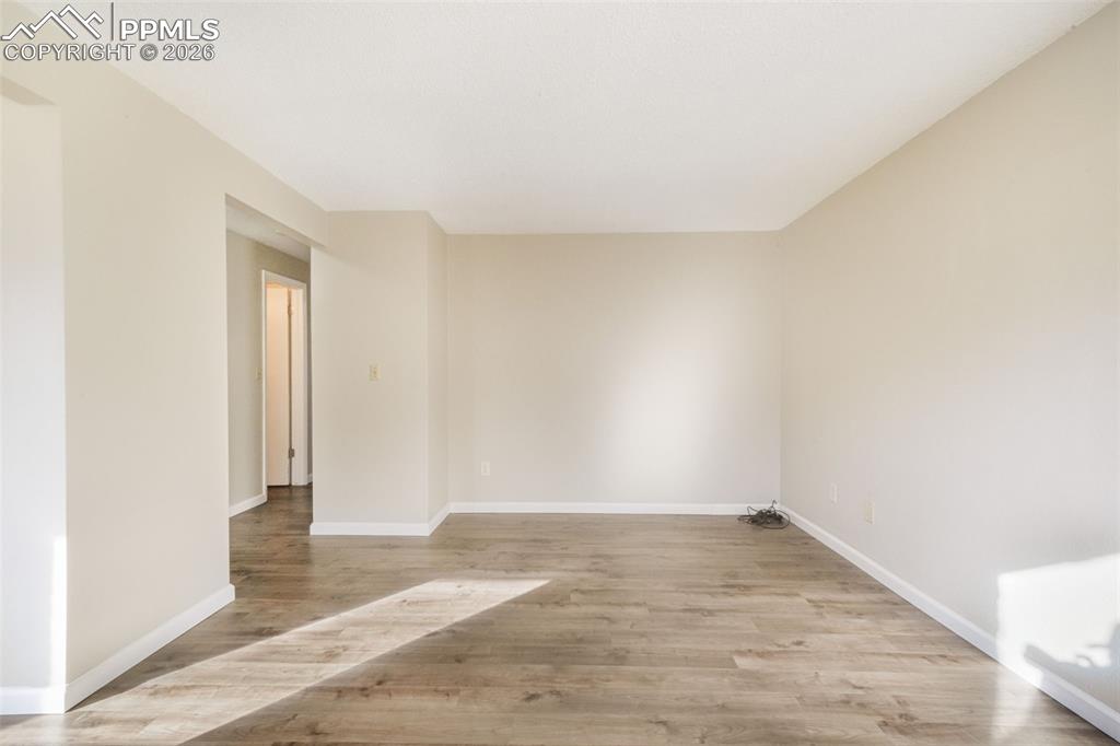 6610 Dublin Loop West, Unit 2 Colorado Springs, CO 80918 - Photo 8 of 50 an empty room with wooden floor and windows