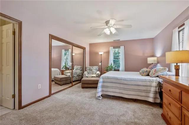 a bedroom with a bed and dresser with mirror