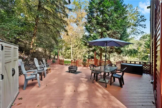 a view of a roof deck with table and chairs under an umbrella with wooden floor