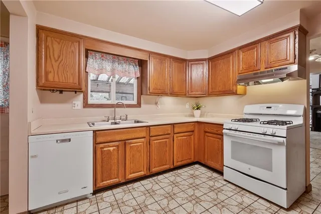 a kitchen with stainless steel appliances granite countertop a refrigerator sink and stove