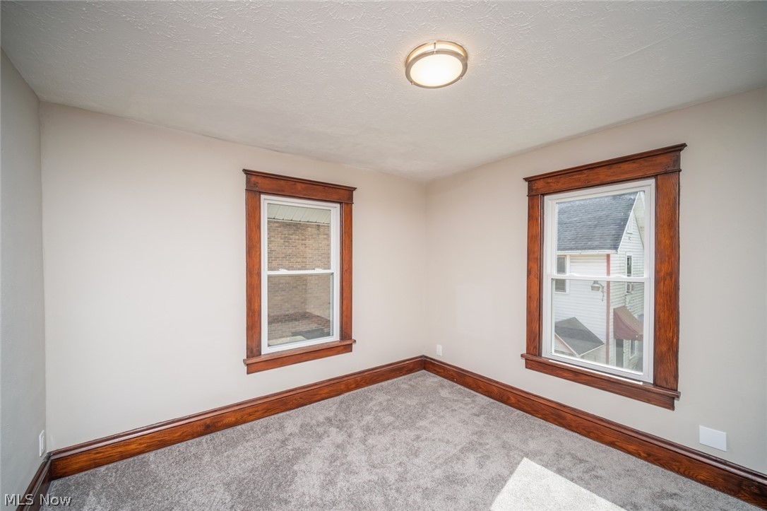 809 Wales Road Northeast Massillon, OH 44646 - Photo 9 of 15 Carpeted spare room featuring a textured ceiling