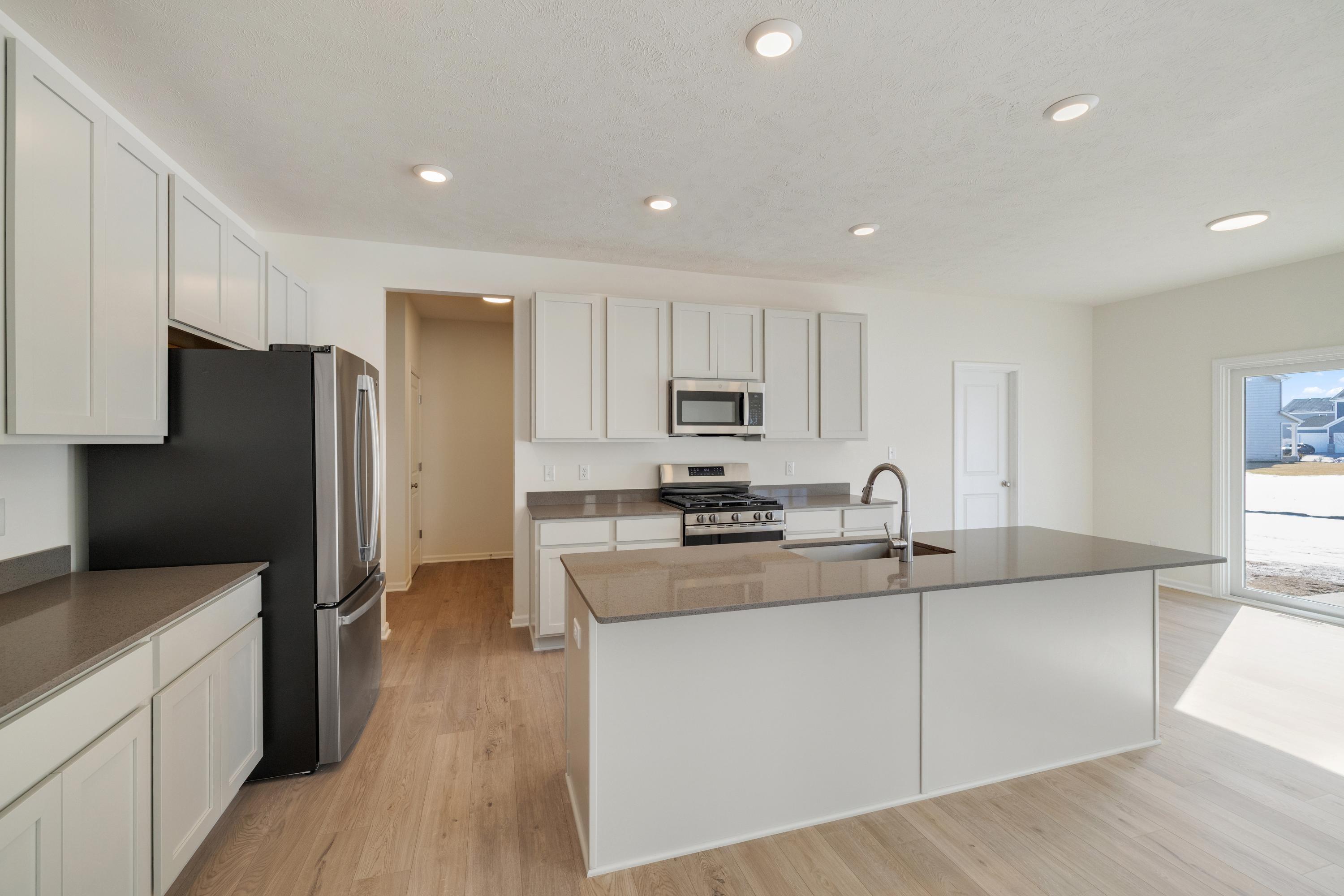 545 East 130th Place Crown Point, IN 46307 - Photo 8 of 25 a kitchen with stainless steel appliances granite countertop a refrigerator a sink dishwasher a stove top oven a refrigerator and white cabinets with wooden floor
