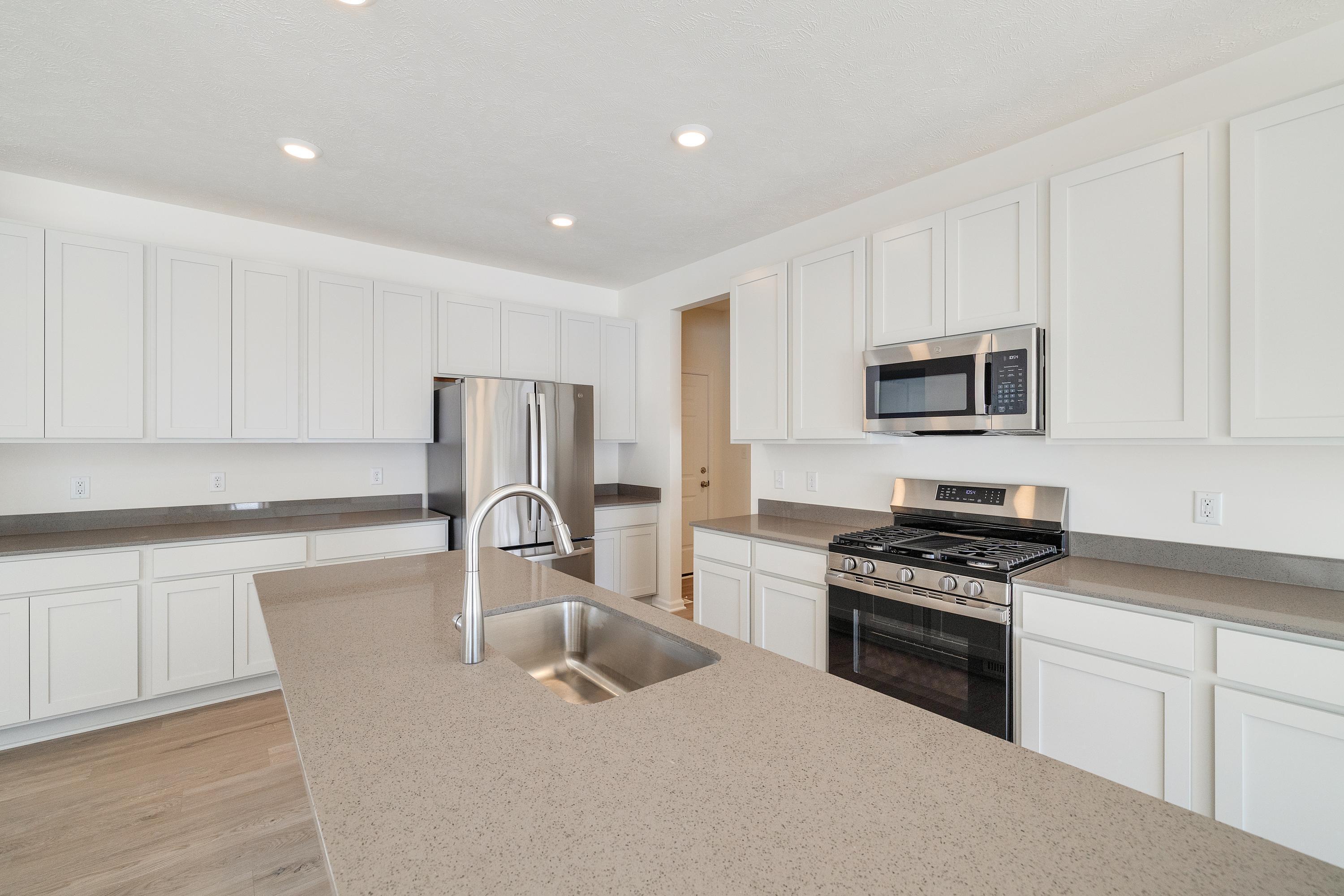 545 East 130th Place Crown Point, IN 46307 - Photo 9 of 25 a kitchen with kitchen island granite countertop a stove sink microwave and refrigerator
