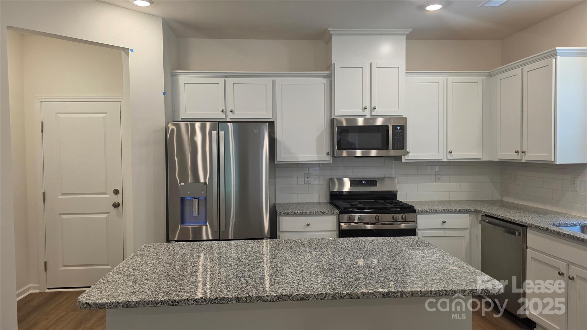 3516 Nimbell Road Monroe, NC 28110 - Photo 5 of 18 a kitchen with granite countertop a refrigerator and a stove top oven