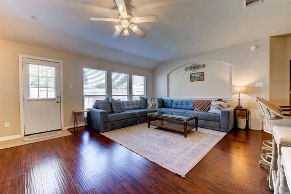 a living room with furniture and a wooden floor