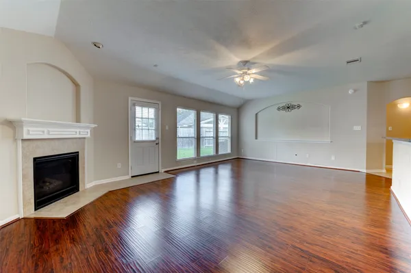 a view of empty room with wooden floor and fireplace