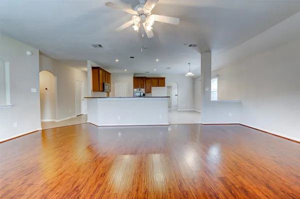 a view of a kitchen with wooden floor and a kitchen space with a sink