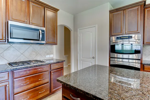 a kitchen with stainless steel appliances granite countertop a stove microwave and cabinets