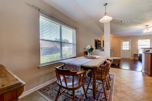 a view of a dining room and livingroom with furniture wooden floor a chandelier