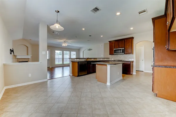 a large kitchen with stainless steel appliances granite countertop a stove and a sink