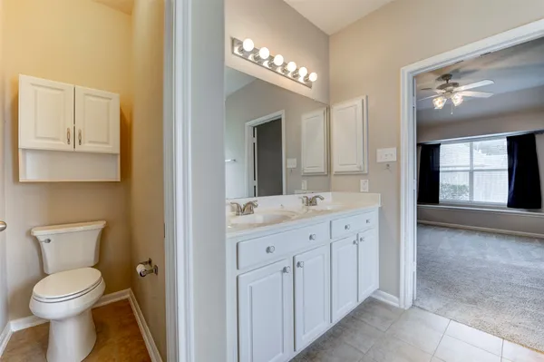 a bathroom with a toilet a sink and mirror