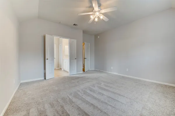 an empty room with a ceiling fan and a window