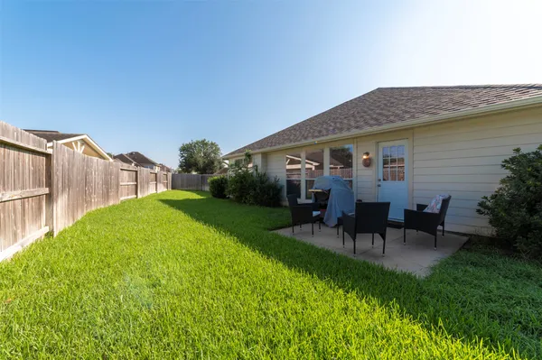 a view of a house with a backyard and a patio