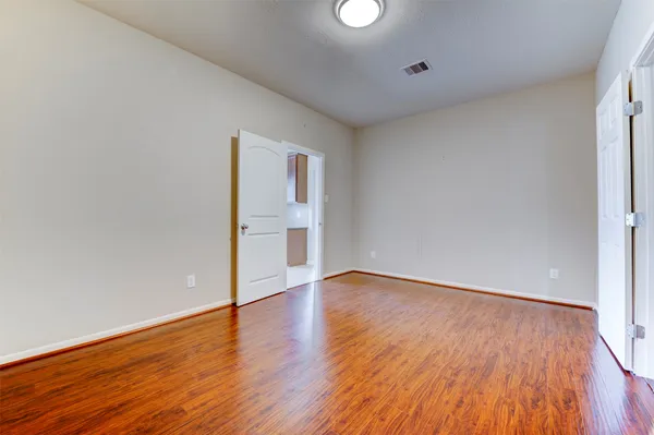 a view of an empty room with wooden floor
