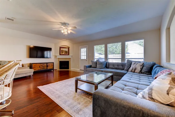 a living room with furniture flat screen tv and wooden floor