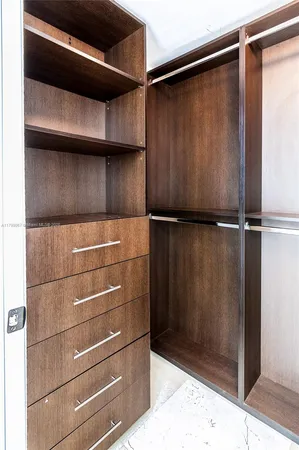an empty room with closet and windows