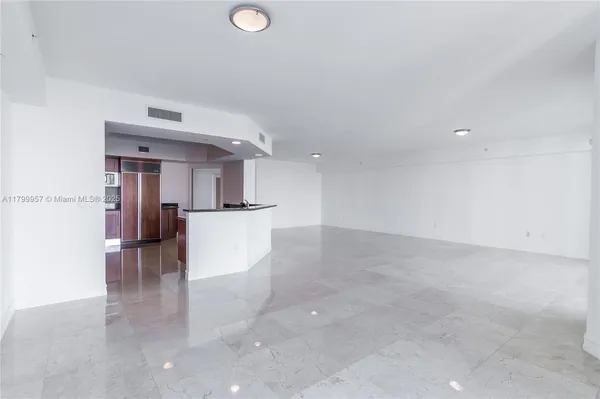 a view of a kitchen with furniture and an empty room