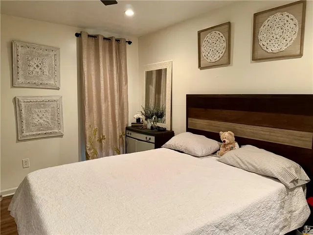 a bedroom with a bed and wooden floor