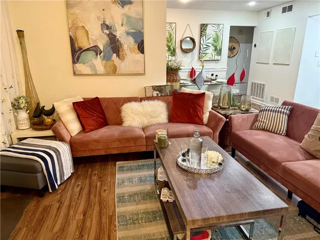 a living room with furniture and wooden floor