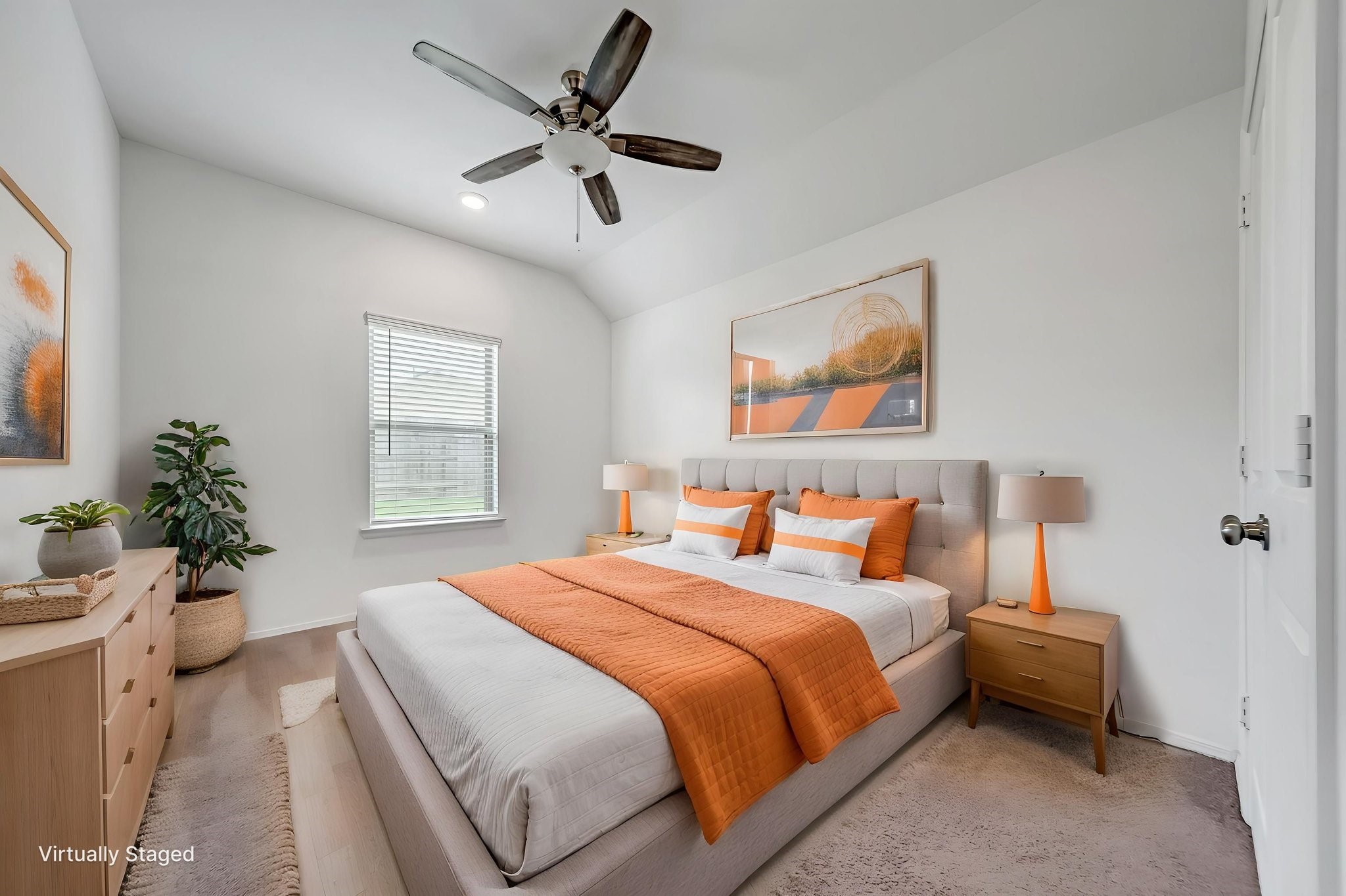 2847 Mistygate Court Conroe, TX 77301 - Photo 12 of 27 This is a bright, cozy bedroom featuring a large bed with orange accents, modern furniture, a ceiling fan, and a window allowing natural light. The space is tastefully decorated with artwork and plants.