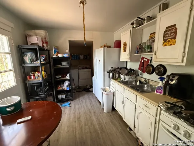 a kitchen that has a lot of cabinets a sink and a stove