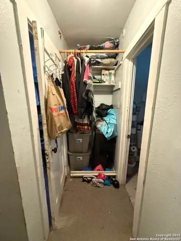 a view of walk in closet with clothes and shoes