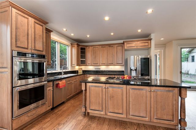a kitchen with stainless steel appliances granite countertop a stove a sink and a microwave