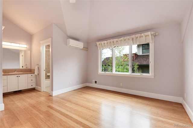 a view of empty room with window and wooden floor