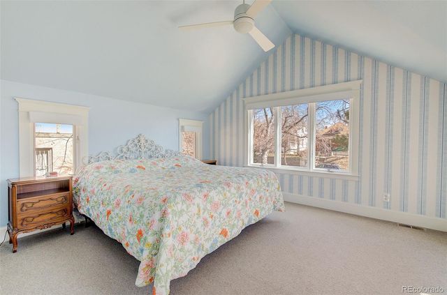 a bed sitting in a spacious bedroom next to a window