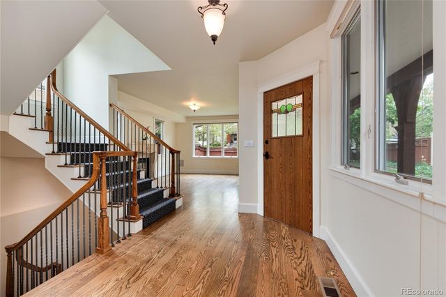 a view of a hallway with wooden floor and staircase
