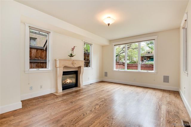wooden floor fireplace and windows in an empty room