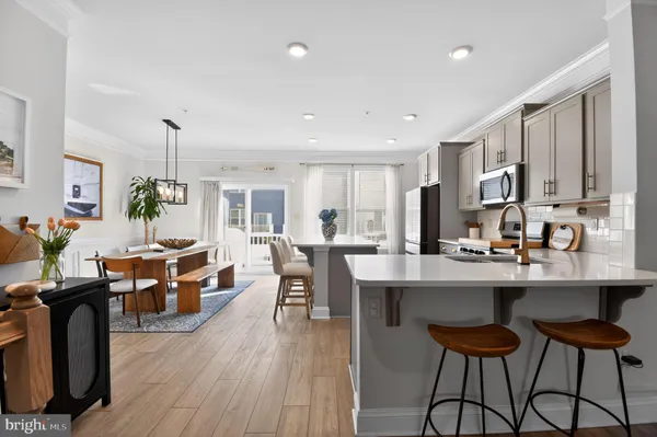 a living room with stainless steel appliances kitchen island granite countertop furniture a dining table and chairs