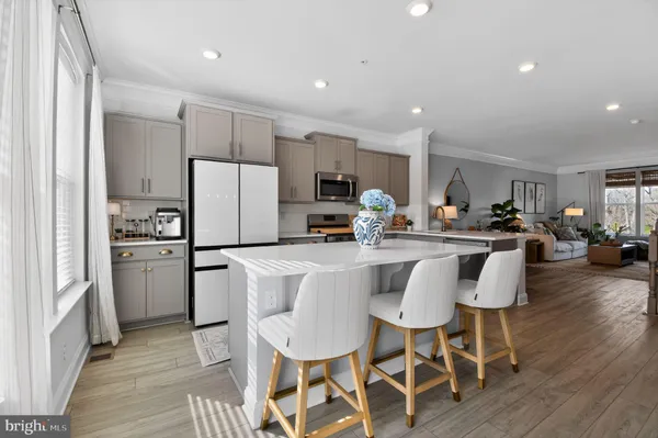a kitchen with refrigerator a sink and chairs