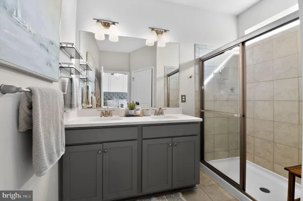 a bathroom with a double vanity sink mirror and shower