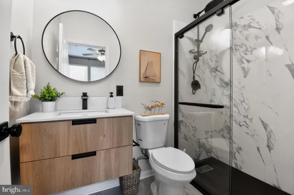 a white toilet sitting next to a bathroom sink and a mirror