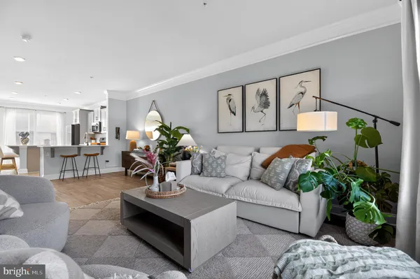a living room with furniture flowers and a chandelier
