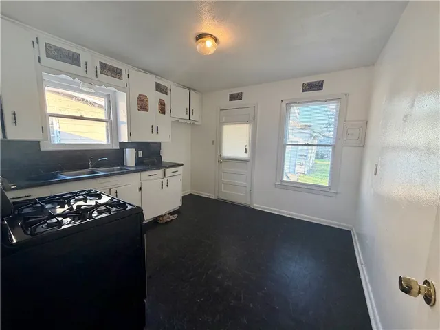 a kitchen with granite countertop a sink cabinets and a window