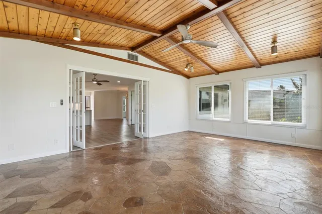 a view of an empty room with wooden floor and window