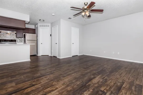 a view of a kitchen with wooden floor and a ceiling fan