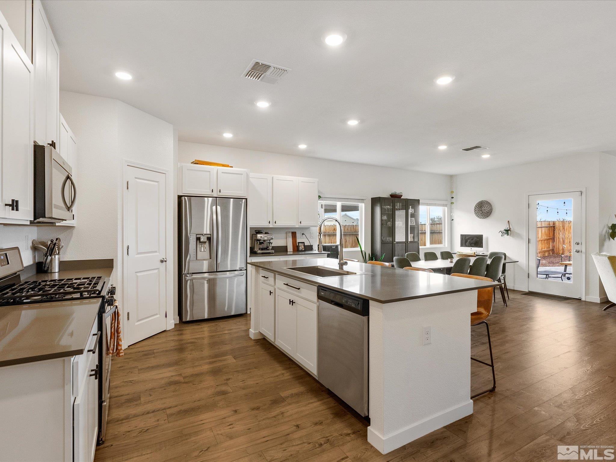 1173 Alder Drive Fallon, NV 89406 - Photo 6 of 40 a kitchen with stainless steel appliances kitchen island granite countertop a stove and a refrigerator