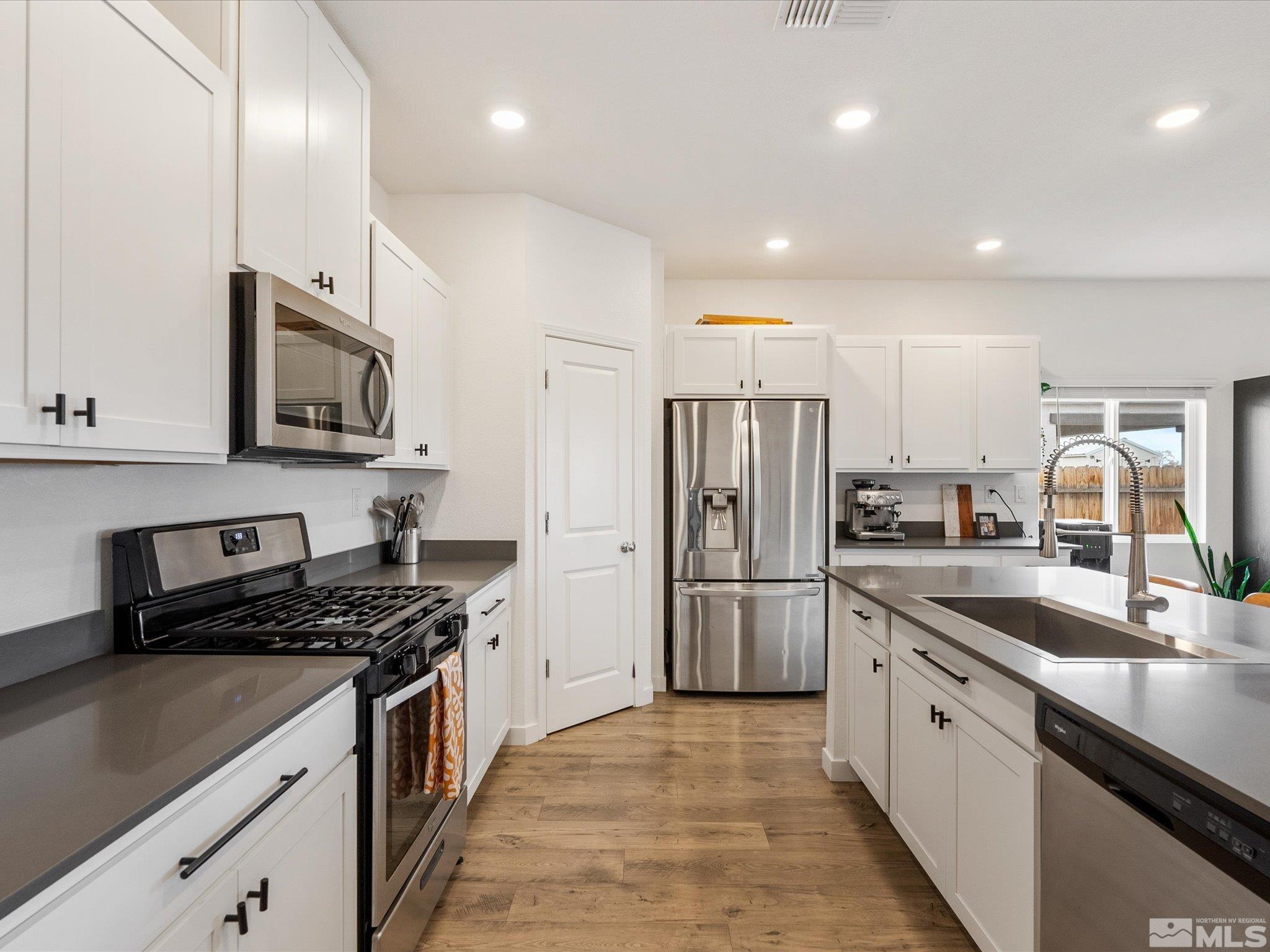 1173 Alder Drive Fallon, NV 89406 - Photo 7 of 40 a kitchen with stainless steel appliances granite countertop a sink stove and refrigerator